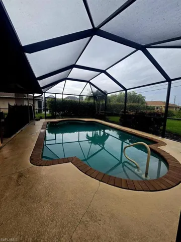 View of pool with a patio area and a lanai