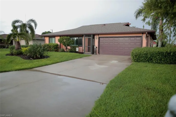 Ranch-style house with a garage and a front lawn