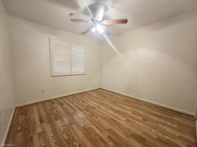 Spare room with hardwood / wood-style flooring and ceiling fan