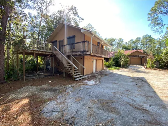 View of front of home with a garage and a wooden deck