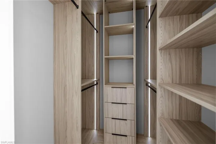 Walk in closet with light wood-style floors