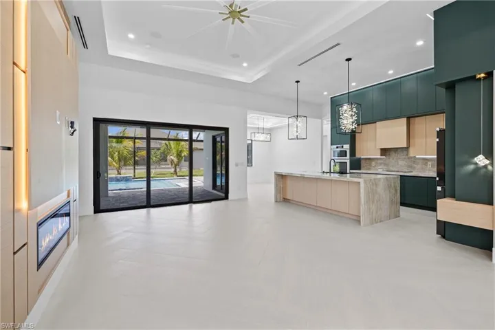 Kitchen with modern cabinets, backsplash, recessed lighting, open floor plan, and custom exhaust hood