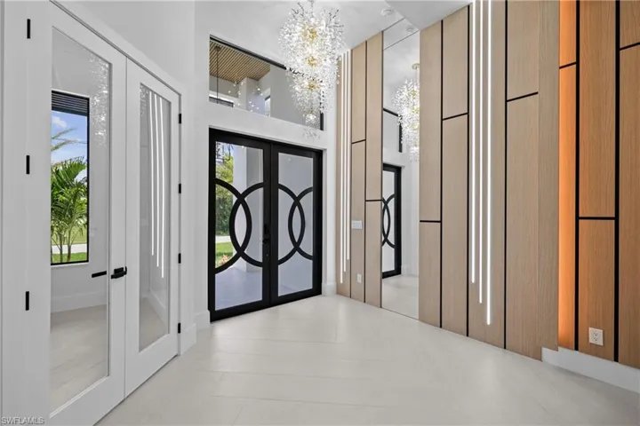 Foyer featuring french doors, a chandelier, and a high ceiling