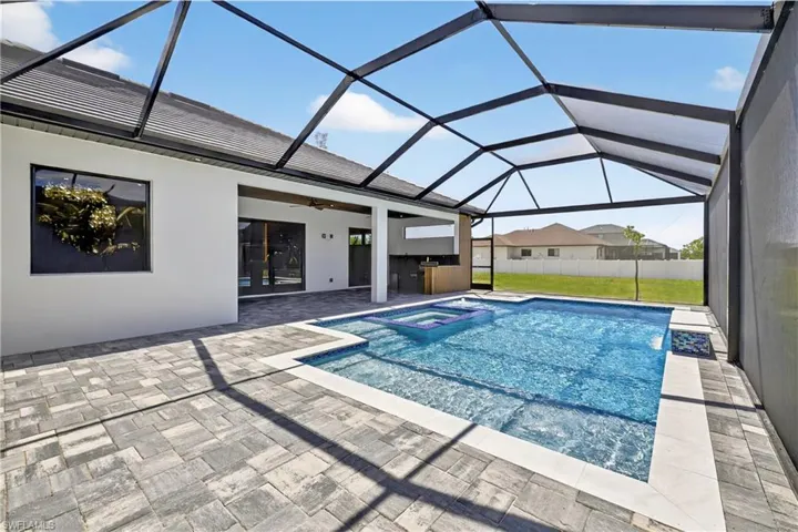 View of swimming pool featuring ceiling fan, a lanai, a patio area, and a pool with connected hot tub