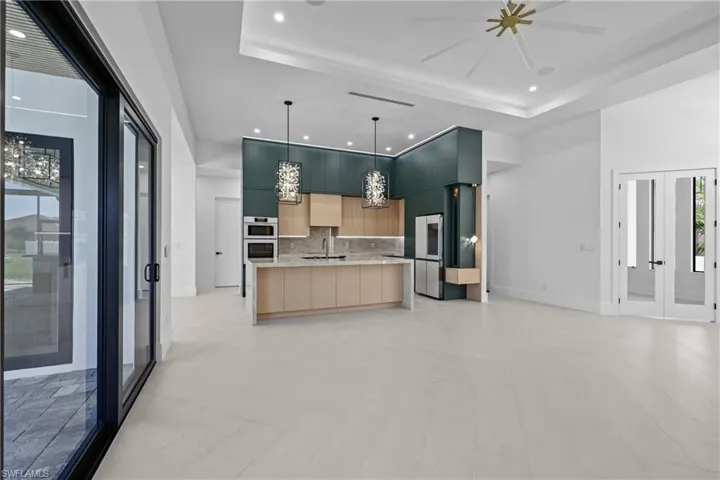 Kitchen with modern cabinets, recessed lighting, open floor plan, french doors, and a tray ceiling