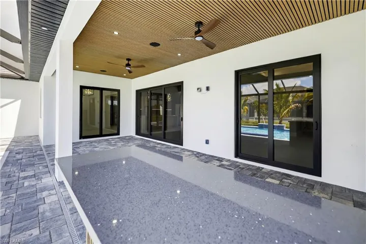 Doorway to property with stucco siding, a patio, and a ceiling fan
