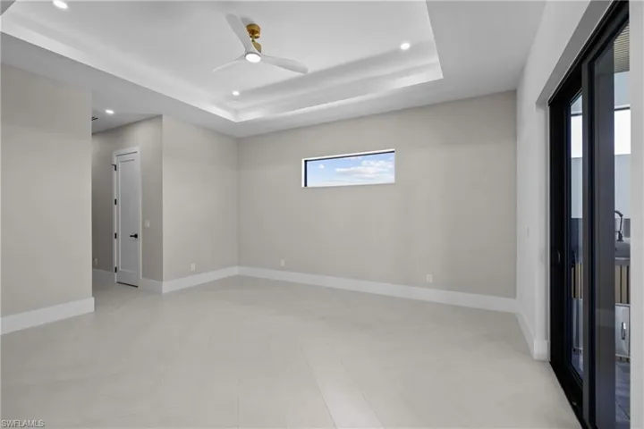 Unfurnished room featuring a ceiling fan, a tray ceiling, and recessed lighting