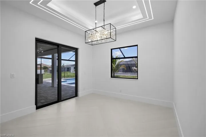 Unfurnished dining area with a tray ceiling and a chandelier