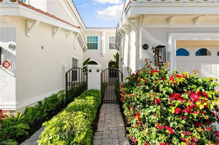 View of exterior entry featuring a gate and stucco siding
