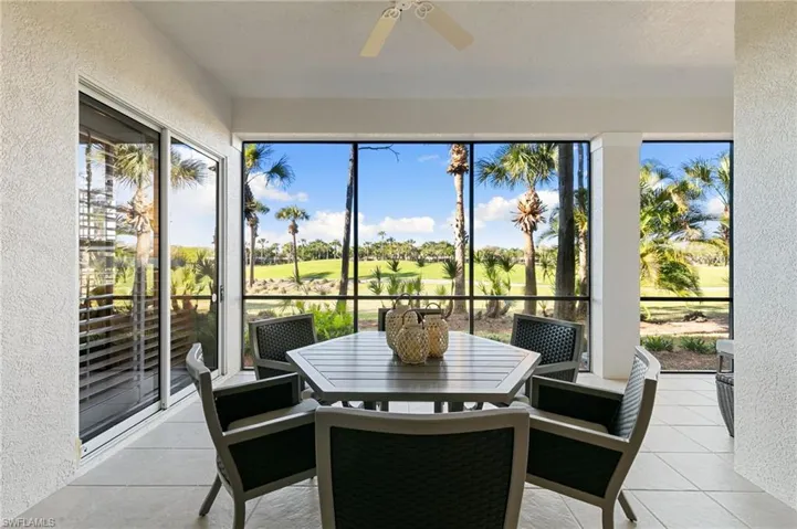 Sunroom / solarium featuring a textured wall, golf course view, and tile patterned flooring