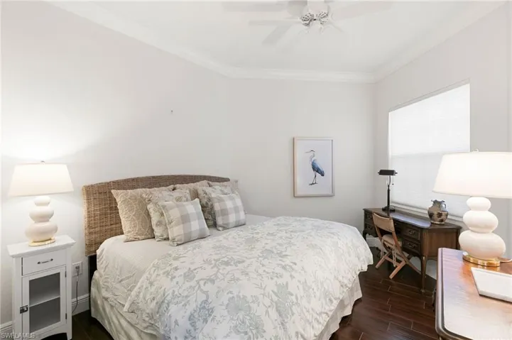 Bedroom with crown molding, wood finish floors, and a ceiling fan
