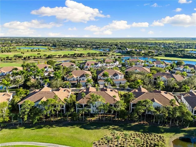 Aerial perspective of suburban area featuring a nearby body of water and a golf club