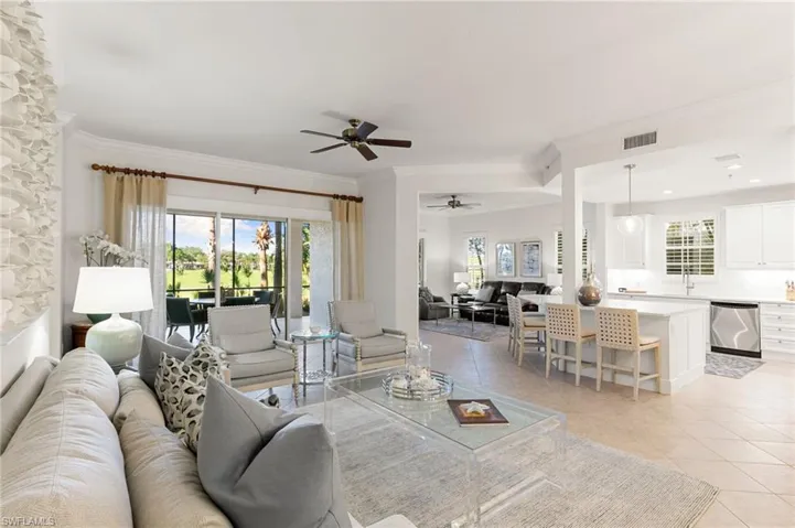 Living room with ornamental molding, ceiling fan, and light tile patterned flooring