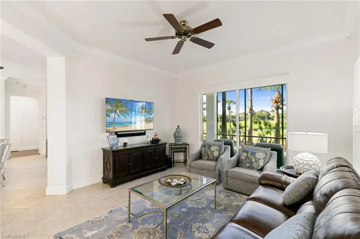 Living area featuring crown molding, ceiling fan, and light tile patterned floors