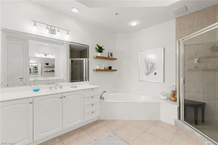 Bathroom with a stall shower, vanity, a bath, and light tile patterned floors