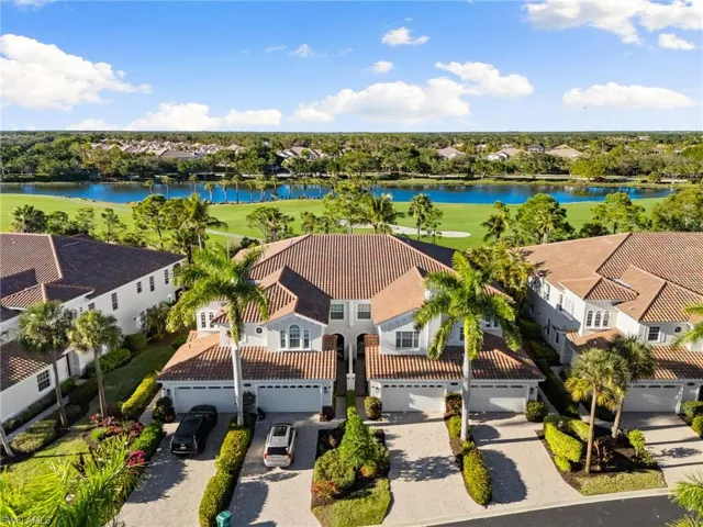 Aerial view of residential area featuring a large body of water and a golf course