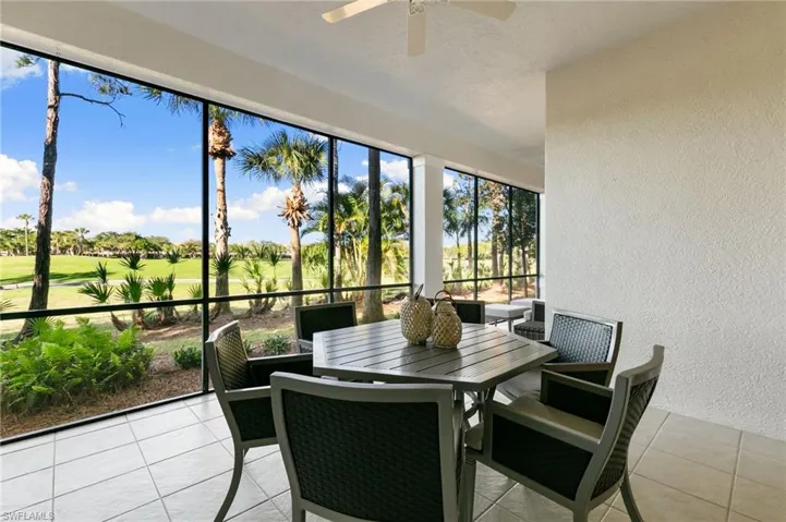 Sunroom featuring a textured wall, view of golf course, and tile patterned floors