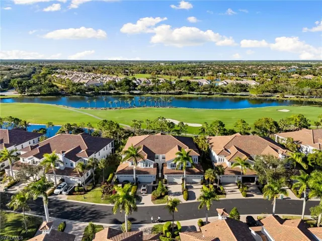 Aerial view of residential area with a local golf course and a nearby body of water
