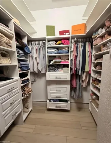 Walk in closet with light wood-style floors