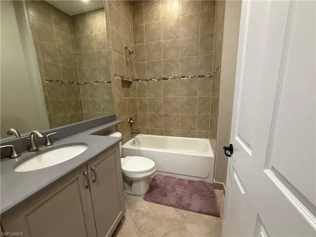 Full bath featuring vanity, shower / bathtub combination, and light tile patterned floors