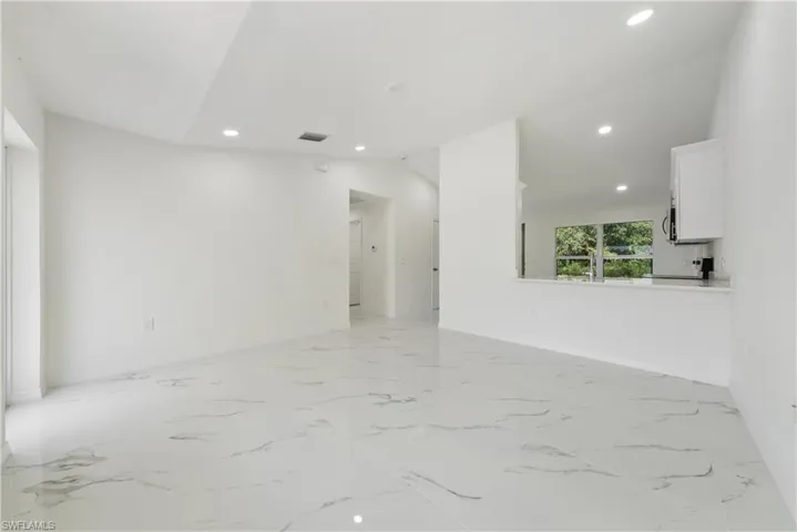 Unfurnished room featuring vaulted ceiling