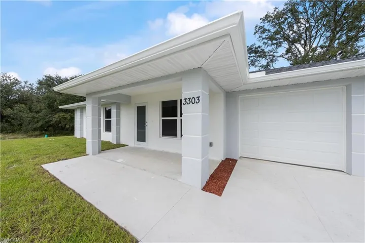 View of front of home with a garage and a front lawn