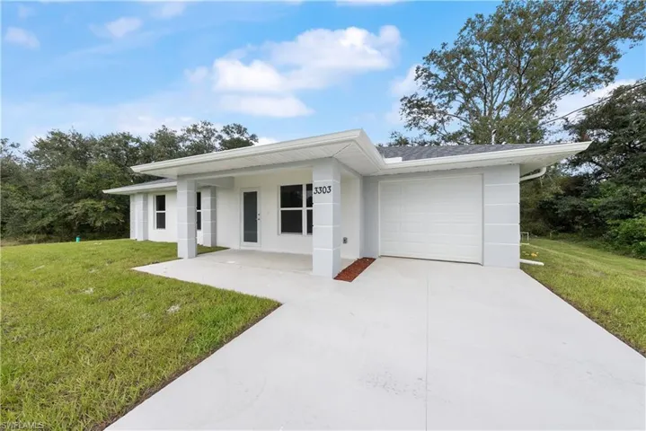 View of front facade featuring a garage and a front yard