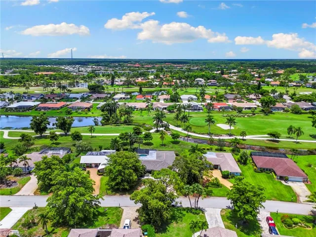 Aerial perspective of suburban area with a nearby body of water and a golf club