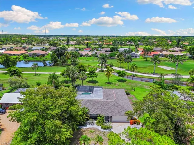 Aerial view of residential area featuring a golf club and a large body of water