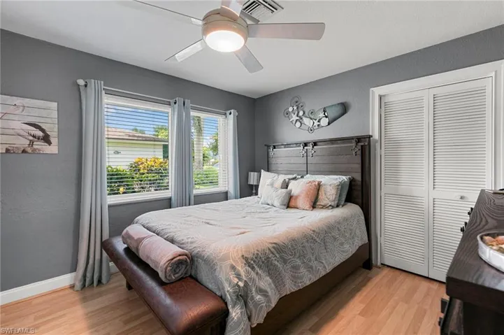Bedroom with light wood-style flooring, a closet, and ceiling fan