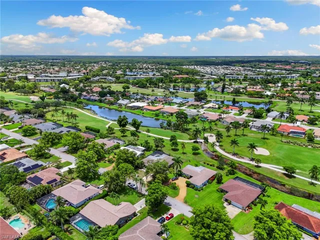 Aerial view of residential area with a local golf course and a large body of water