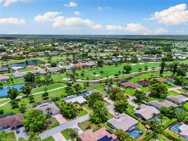 Aerial view of residential area featuring a large body of water and a local golf course