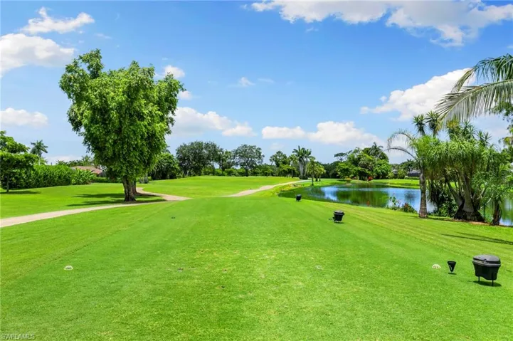 Surrounding community with a water view, view of golf course, and a lawn