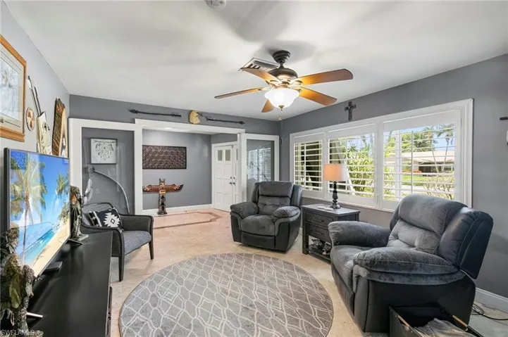 Living room featuring light carpet and a ceiling fan