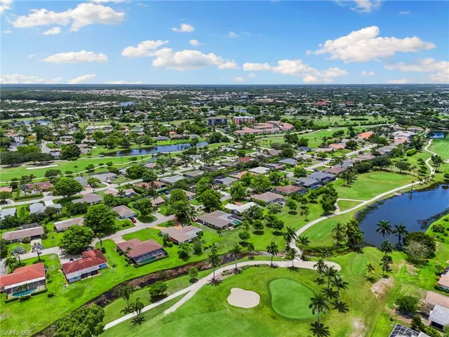 Aerial perspective of suburban area with a nearby body of water and a local golf course
