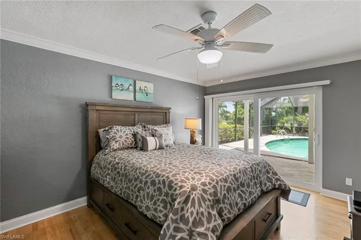 Bedroom with access to outside, light wood finished floors, crown molding, a textured ceiling, and a ceiling fan
