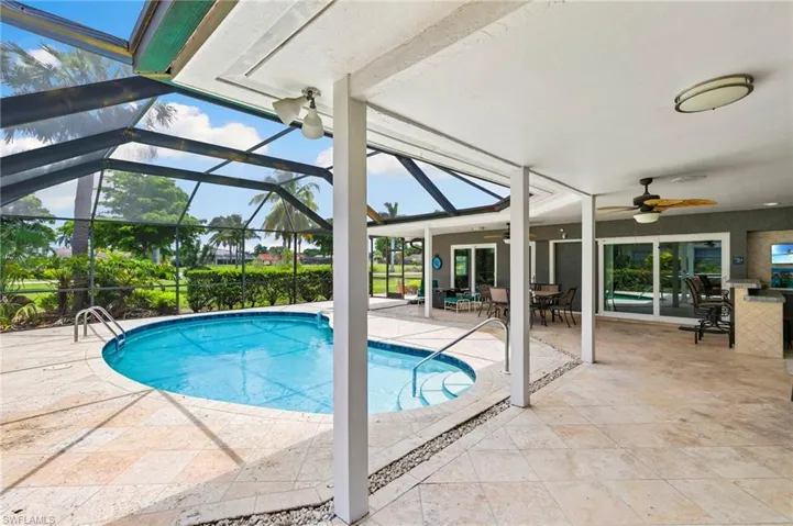 Outdoor pool with a ceiling fan, a patio, outdoor dining space, and glass enclosure