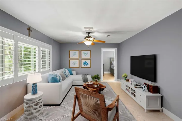 Living area featuring a ceiling fan and baseboards