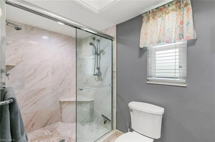 Bathroom featuring a shower stall and toilet