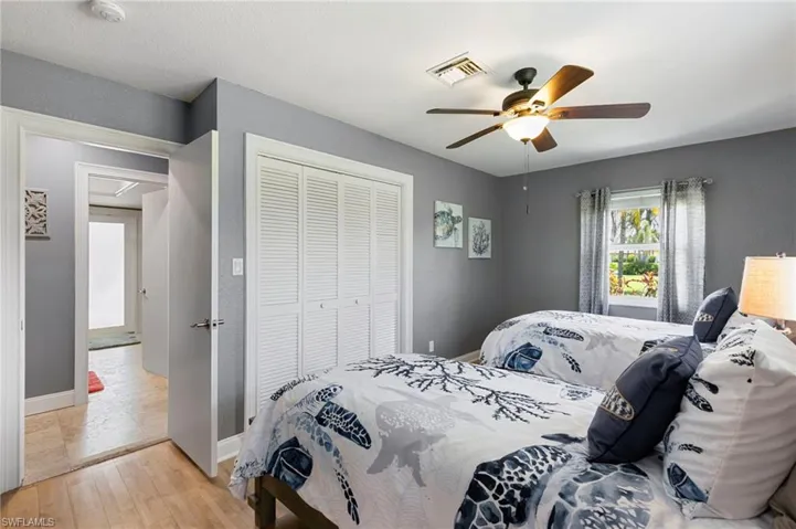 Bedroom with light wood finished floors, a closet, and ceiling fan