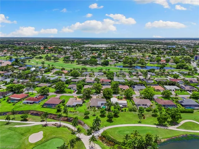 Aerial perspective of suburban area with a golf club and a large body of water