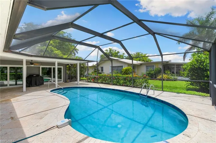 Swimming pool with a patio, ceiling fan, a grill, and a lawn