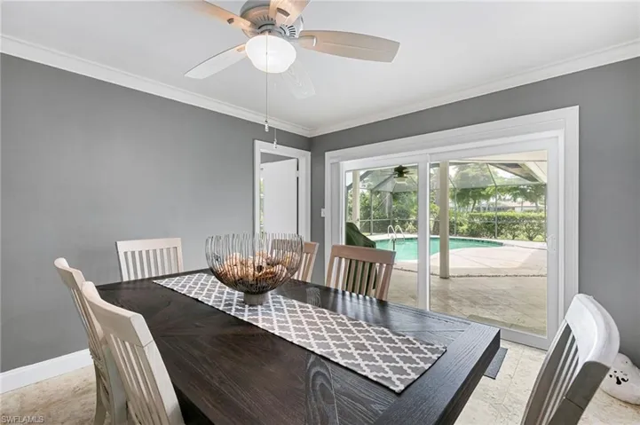 Dining area with a ceiling fan and ornamental molding