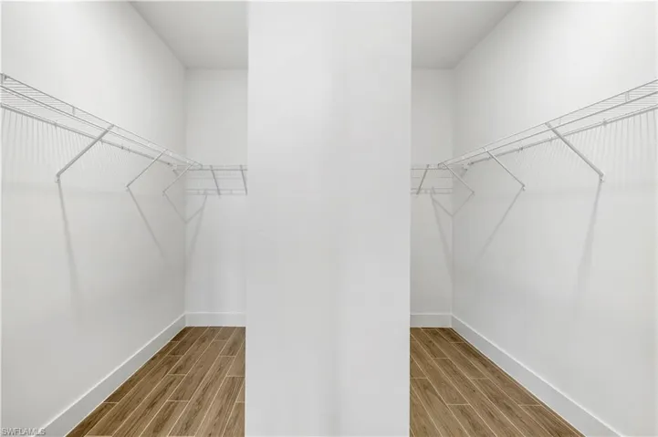 Primary bedroom closet with dividing wall