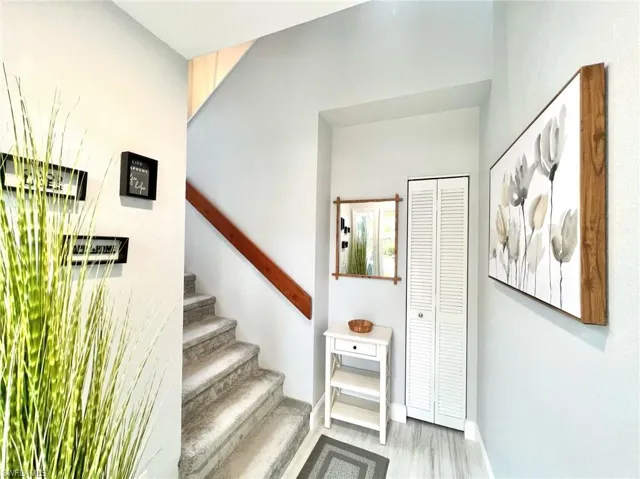 Entrance with stairs featuring baseboards and wood finished floors