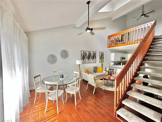 Dining area featuring stairway, beam ceiling, wood finished floors, and a ceiling fan