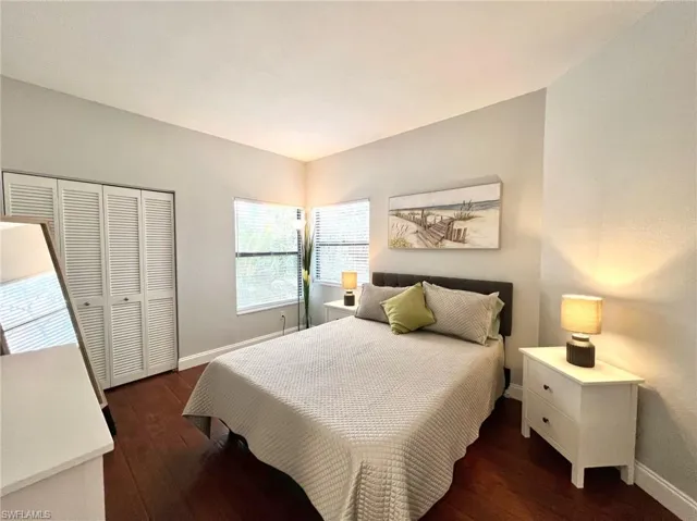 Guest Bedroom featuring dark wood-style floors, baseboards, and a closet
