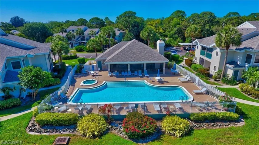 Community pool with a patio area, a residential view, and fence