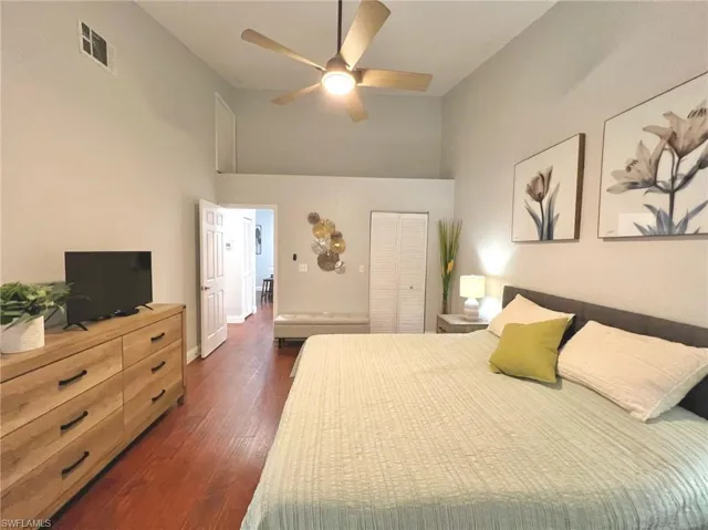 Master Bedroom with dark wood-type flooring, a closet, visible vents, and a towering ceiling