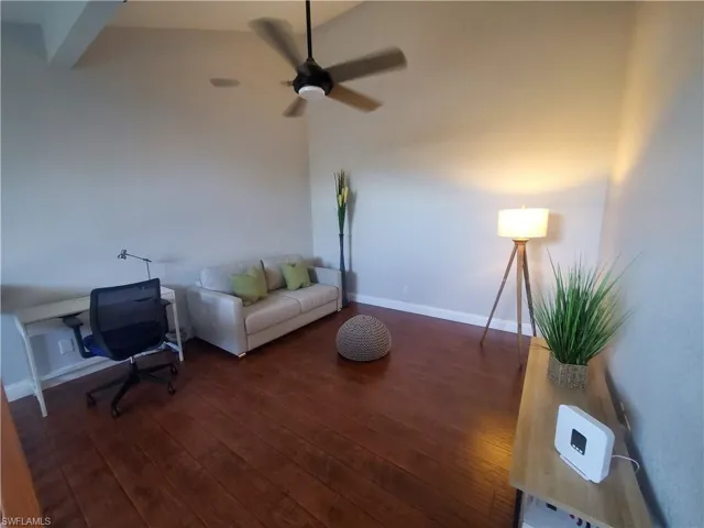Living room with a ceiling fan and dark wood finished floors